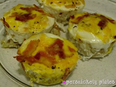 Bird's Nest Breakfast Cups are a fun way to eat eggs and hash browns for breakfast. These baked egg cups combine hash browns and cheese to form a "nest" and are topped with an egg. | www.persnicketyplates.com bird's nest breakfast cups topped with bacon