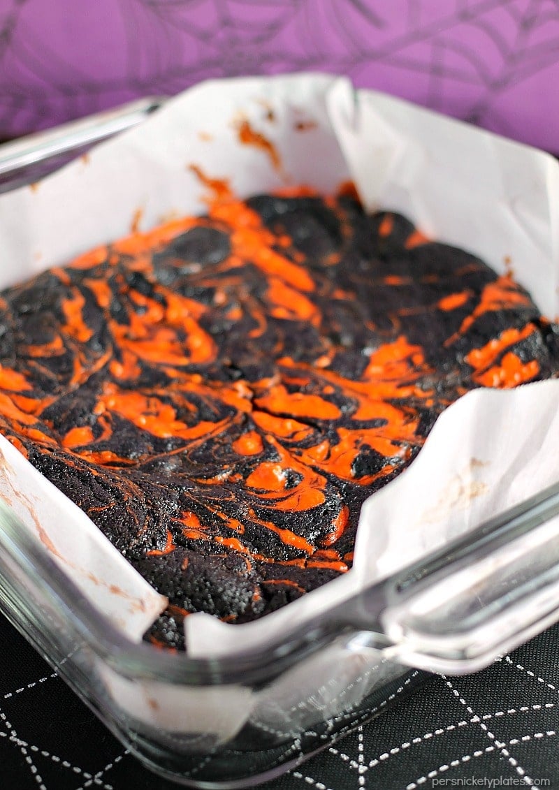 Halloween Cream Cheese Swirl Brownies have a layer of rich, dark chocolate brownie topped with a layer of orange cheesecake then swirled together for a spooky treat. | Persnickety Plates
