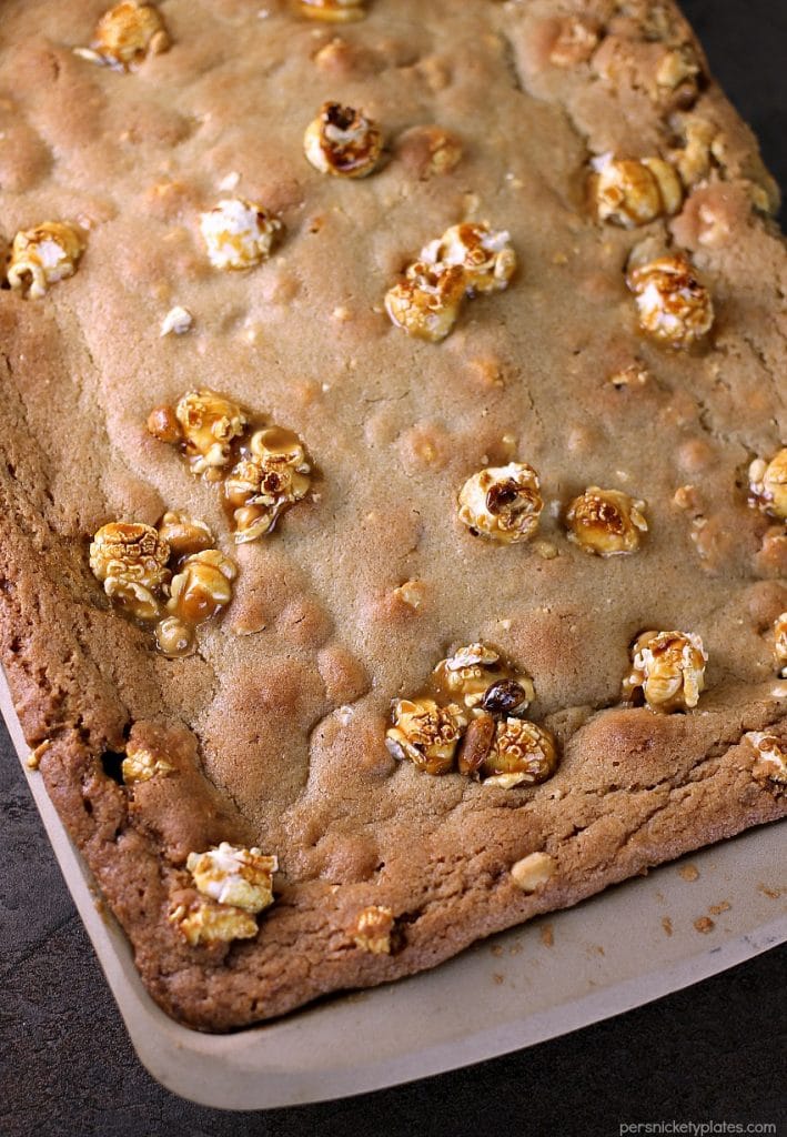 Crunch 'n Munch Cookie Bars have a soft, chewy, and buttery base with sweet & salty popcorn scattered throughout. They pair perfectly with Papa John's new pan pizza for game day or any night! | www.persnicketyplates.com