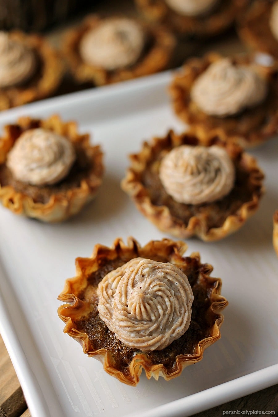 Mini Sweet Potato Pies with Cinnamon Cream Cheese Frosting are super easy to make but look fancy. Impress your guests with these bite sized treats! | www.persnicketyplates.com #pie #sweetpotatopie #thanksgiving #minidessert #dessert bite size sweet potato pies with cream cheese frosting