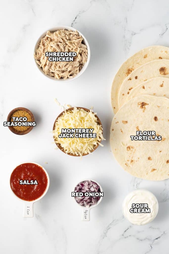 overhead shot of labeled ingredients laid out to make chicken enchiladas.