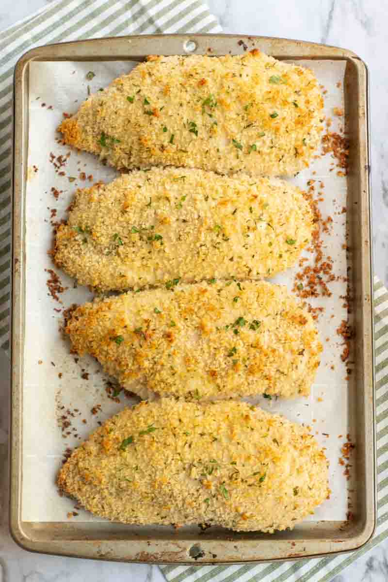 Four baked Laughing Cow Chicken breasts on a baking sheet frest from the oven Laughing Cow Chicken is a lightened up version of a stuffed chicken breast. This super easy, 5 ingredient dinner will please your picky eaters and wow your foodies. | www.persnicketyplates.com