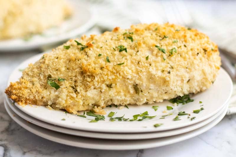 Laughing Cow Stuffed Chicken sitting on top of three white plates with a parsley garnish Laughing Cow Chicken is a lightened up version of a stuffed chicken breast. This super easy, 5 ingredient dinner will please your picky eaters and wow your foodies. | www.persnicketyplates.com