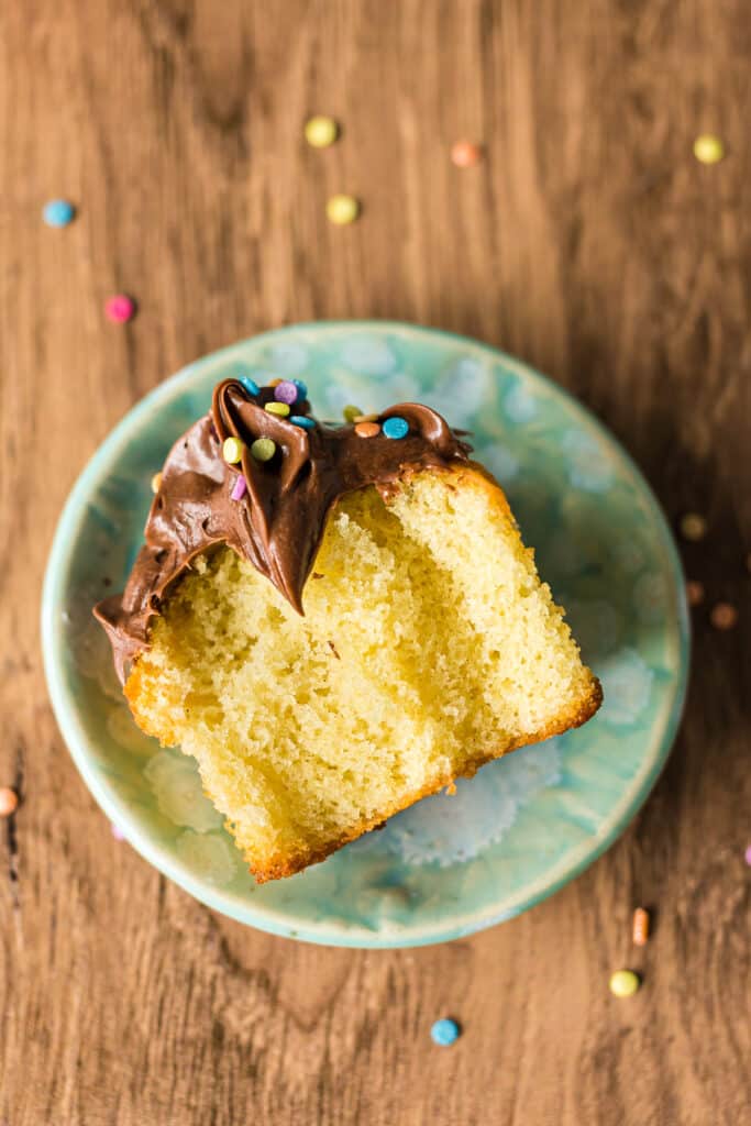 a yellow cupcake on its side with bites taken out.