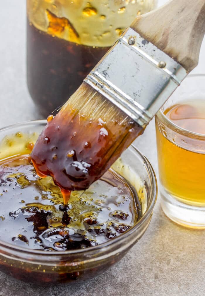 pastry brush dipping into jack daniel's sauce