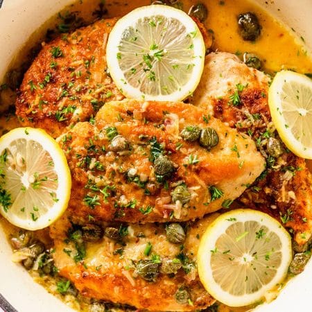 chicken piccata covered in capers and lemon slices.