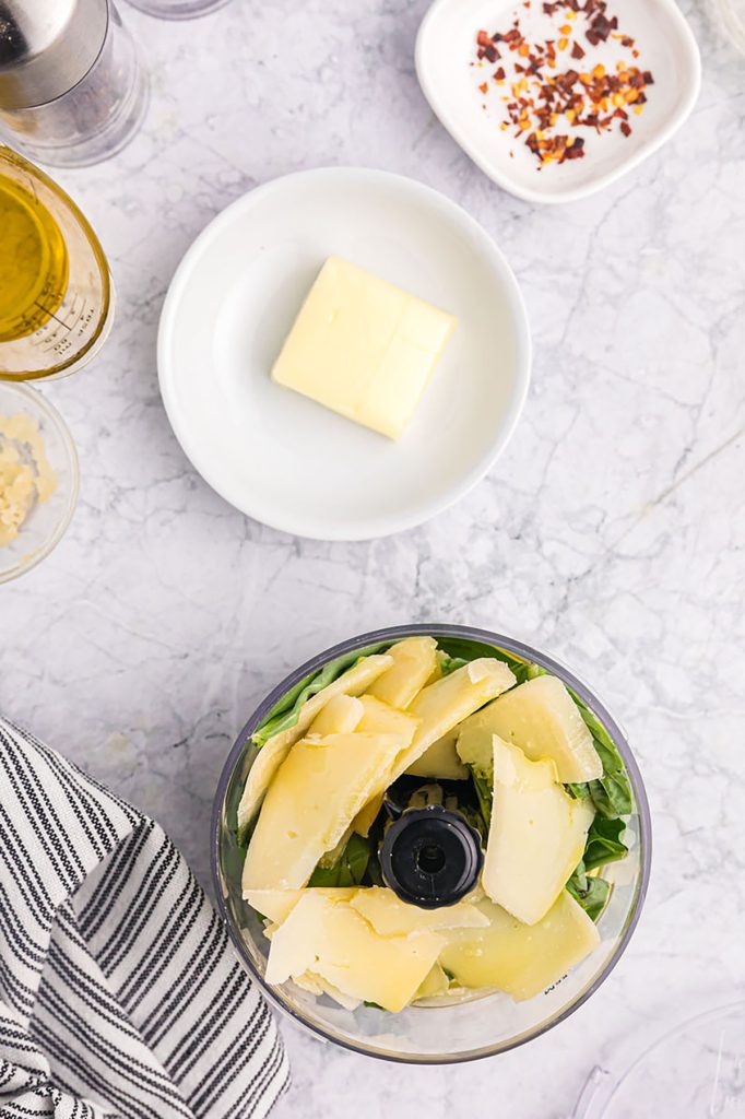 overhead shot of pesto being made in a mini food processor.