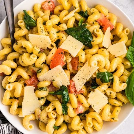 overhead shot of pesto cavatappi topped with shaved cheese.