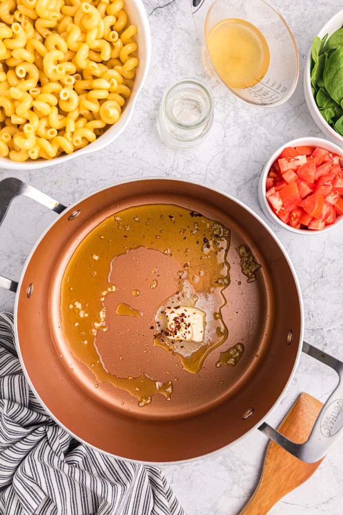 overhead shot of melted butter and red pepper flakes in a pot.