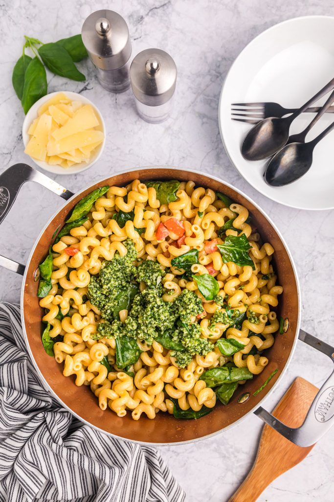 pesto in a pot of cavatappi noodles.