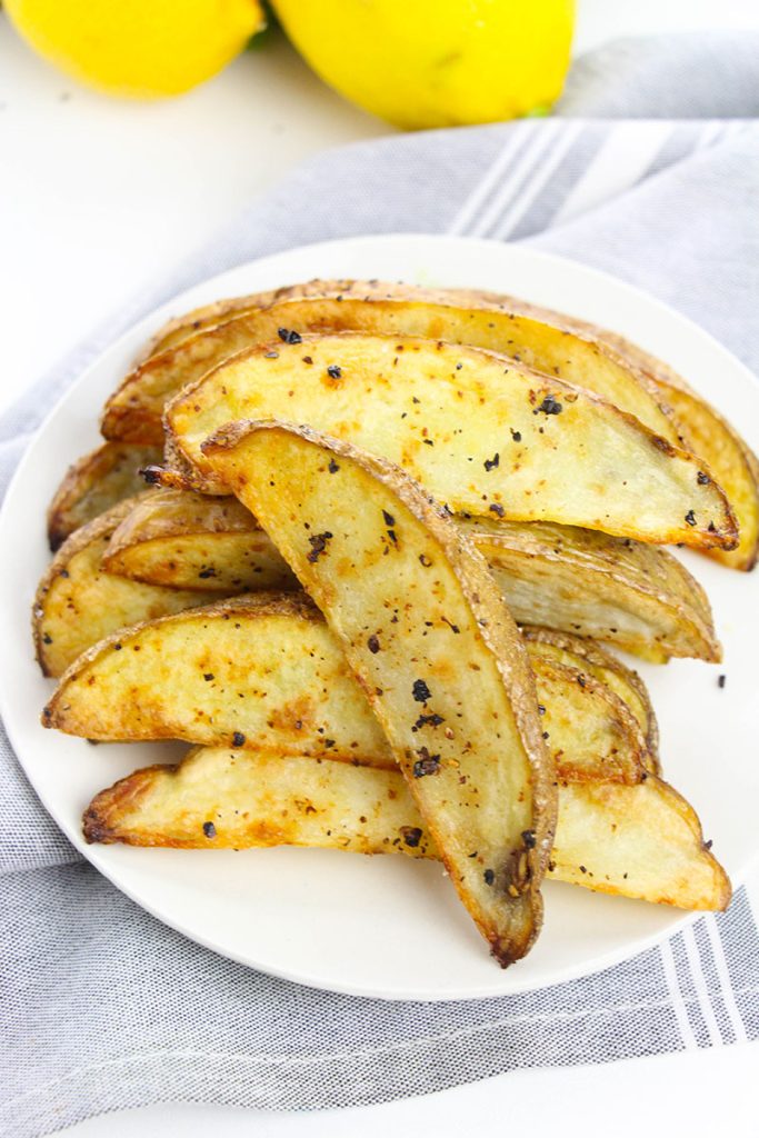 overhead shot of oven baked potato wedges on a white plate.
