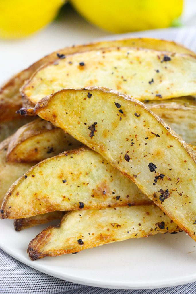 white plate full of crispy potato wedges.