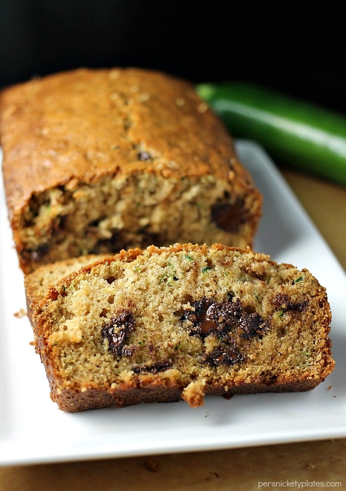 I've been making this Paula Deen Zucchini Bread recipe for years because it really is the best zucchini bread! It's easy to prepare and it makes two loaves so you can share. | www.persnicketyplates.com #zucchinibread #quickbread #dessert #zucchini #chocolatechips sliced paula deen zucchini bread on white platter