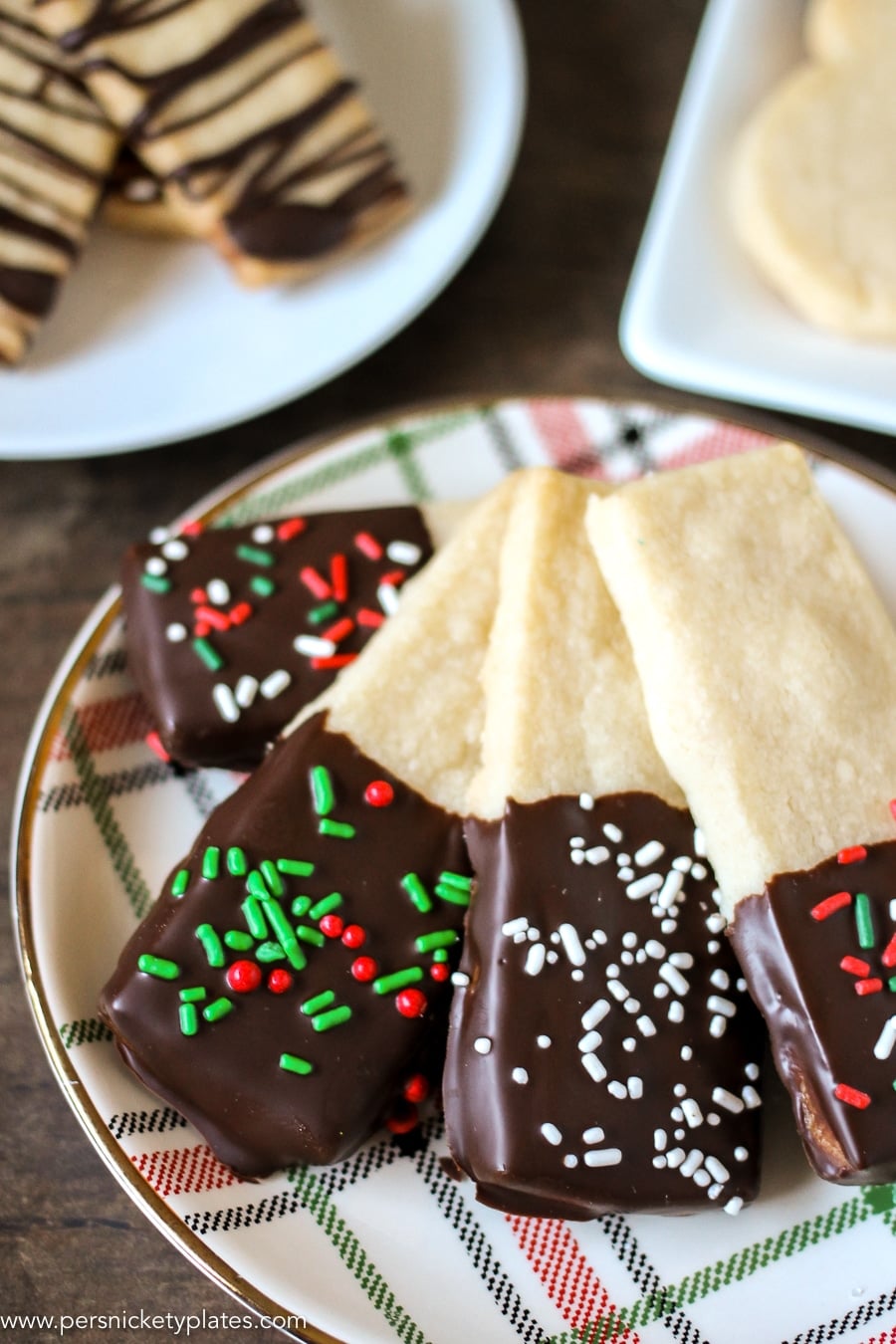 Chocolate Dipped Shortbread Cookies are a simple, from-scratch, shortbread cookie dipped in dark chocolate that's perfect for dunking in milk, coffee, hot chocolate...Santa won't be disappointed with these shortbread Christmas cookies! | www.persnicketyplates.com #christmascookies #shortbread #easyrecipe #baking #cookies #chocolate #sprinklesChocolate Dipped Shortbread Cookies are a simple, from-scratch, shortbread cookie dipped in dark chocolate that's perfect for dunking in milk, coffee, hot chocolate...Santa won't be disappointed with these shortbread Christmas cookies! | www.persnicketyplates.com #christmascookies #shortbread #easyrecipe #baking #cookies #chocolate #sprinkles plate of christmas chocolate dipped shortbread cookies