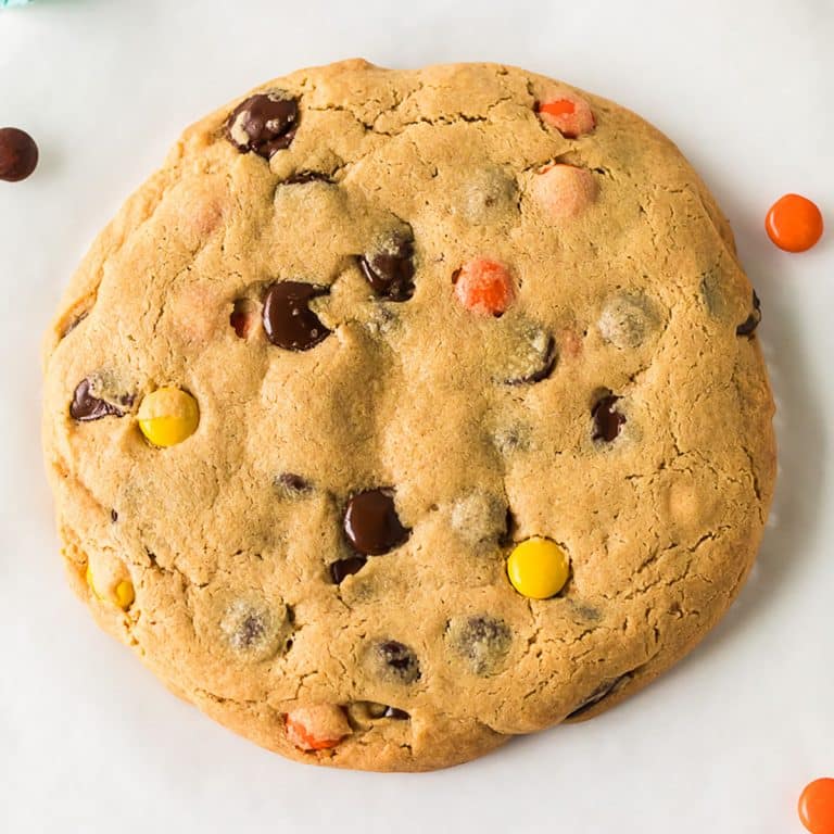 overhead shot of a giant peanut butter cookie with chocolate chips & reese's pieces.