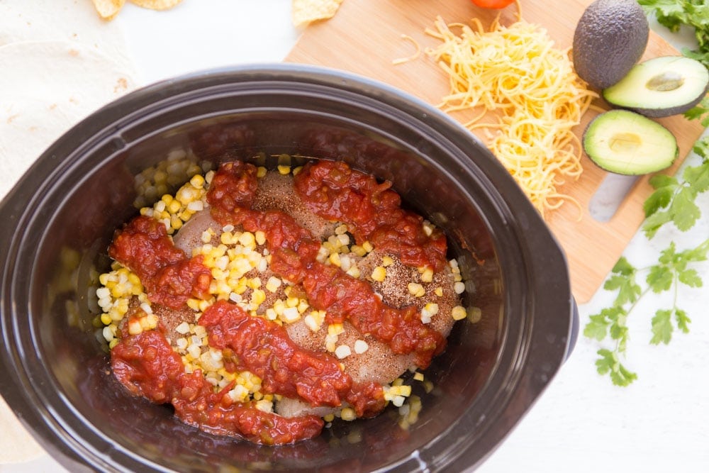 chicken, salsa, and corn in slow cooker Three ingredient Crock Pot Salsa Chicken is in my regular dinner rotation because it's so easy & so good! Flavorful and versatile, this crockpot chicken breast recipe can be made into burritos, taco bowls, nachos, whatever you feel like!