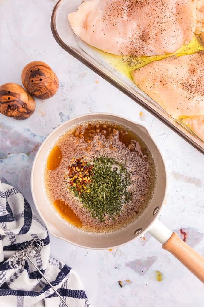 overhead shot of melted butter and herbs in a saucepan.