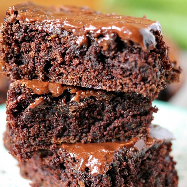 Zucchini Brownies are moist and chocolaty with a simple frosting. They also happen to be dairy-free/vegan. You'll never know there's zucchini hidden in them! | www.persnicketyplates.com