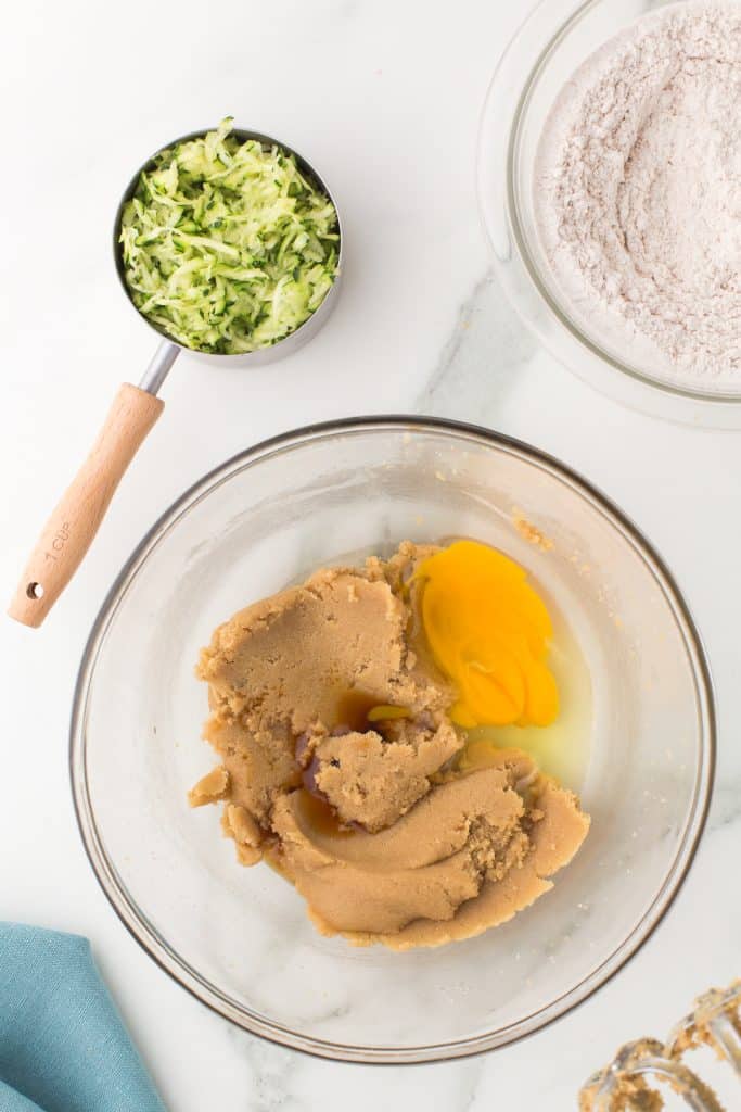 overhead shot of a mixing bowl with sugars and egg.