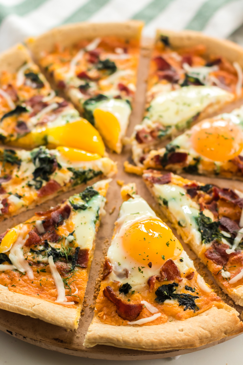 Bacon & spinach breakfast pizza is a filling and unique way to start your day. Pizza for breakfast is always a good idea! | www.persnicketyplates.com #pizza #breakfast #breakfastpizza #easyrecipe close up of sliced breakfast pizza