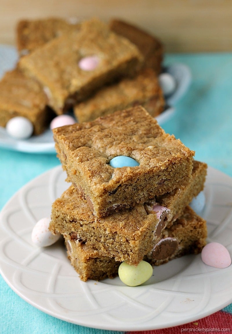 stack of Cadbury Mini Eggs Cookie Bars on white plate stack of cookie bars with cadbury mini eggs