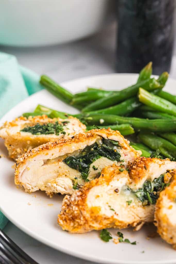 Cajun stuffed chicken breasts sliced with spinach and cheese filling, served with green beans.