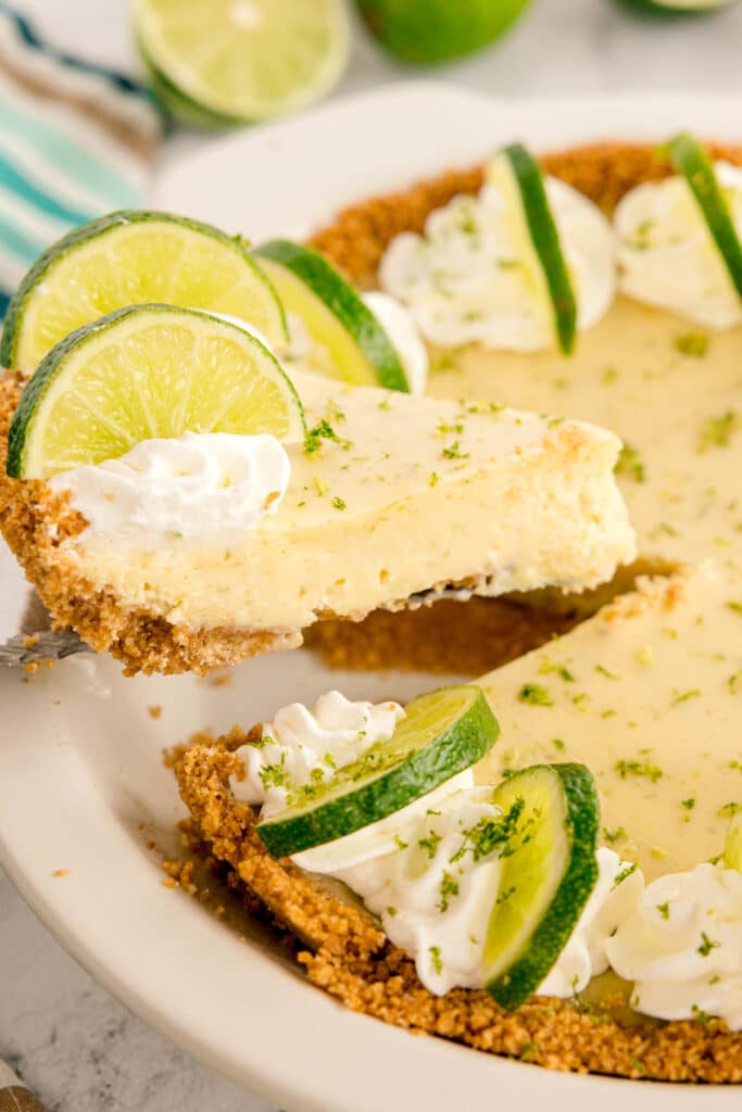 lifting a slice of key lime pie out of a pie plate.