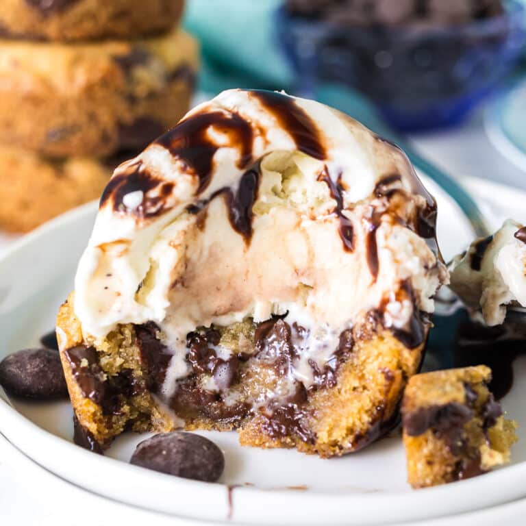 chocolate chip cookie cup topped with vanilla ice cream and chocolate sauce.