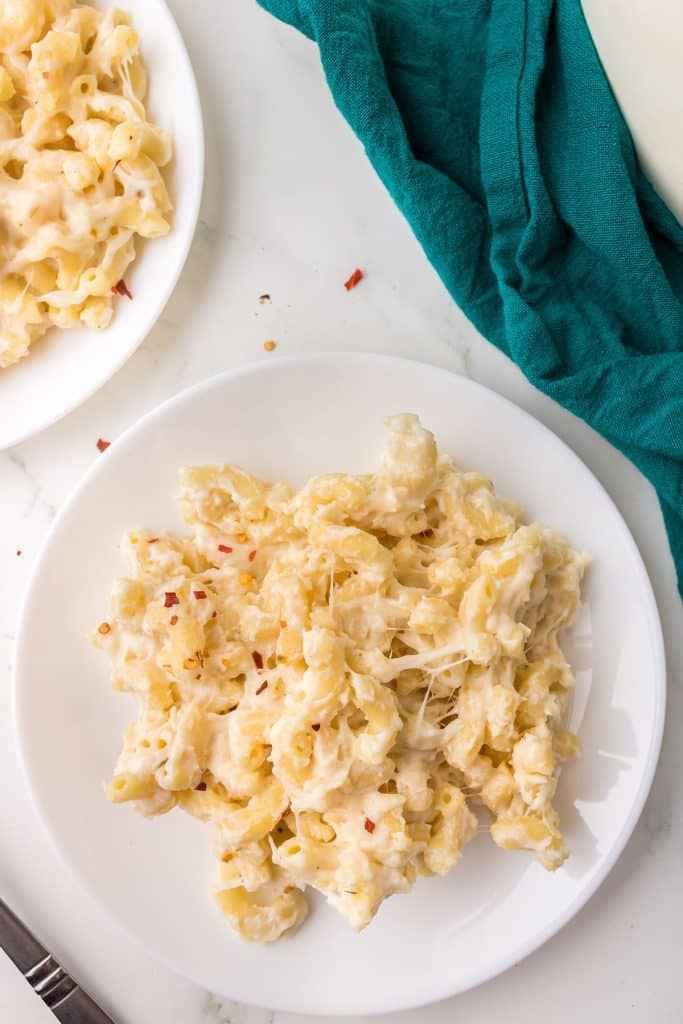 overhead shot of creamy macaroni and cheese on a white plate.