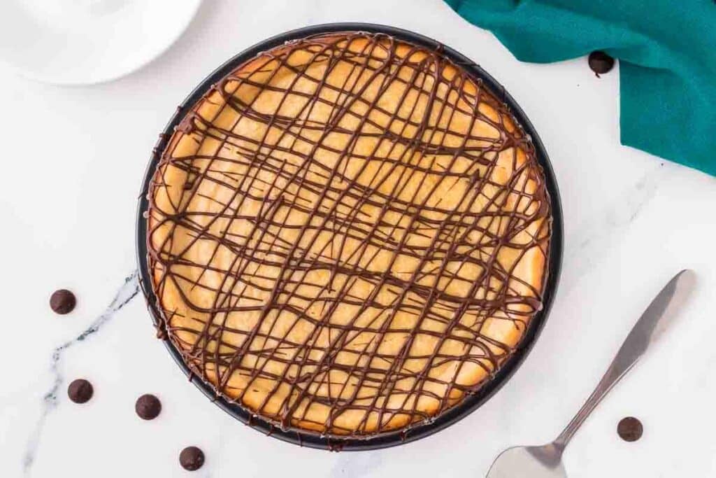 overhead shot of a peanut butter cheesecake drizzled with chocolate.