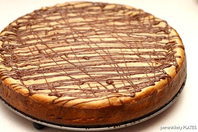 Brownie Bottom Peanut Butter Cheesecake has a layer of chewy brownie topped with a creamy peanut butter cheesecake and drizzled with rich chocolate. | www.persnicketyplates.com #cheesecake #peanutbutter #brownie #dessert