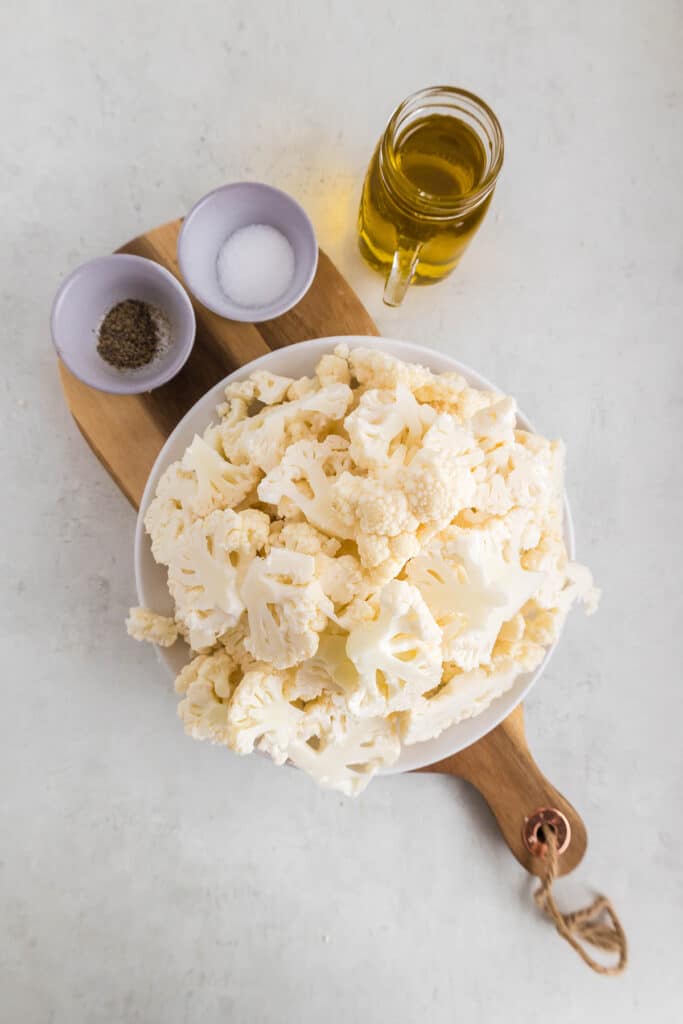 overhead shot of chopped cauliflower, oil, and seasonings.