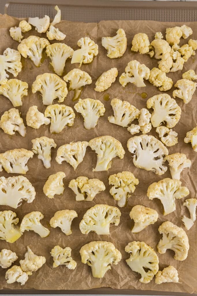 seasoned cauliflower florets on a baking sheet.