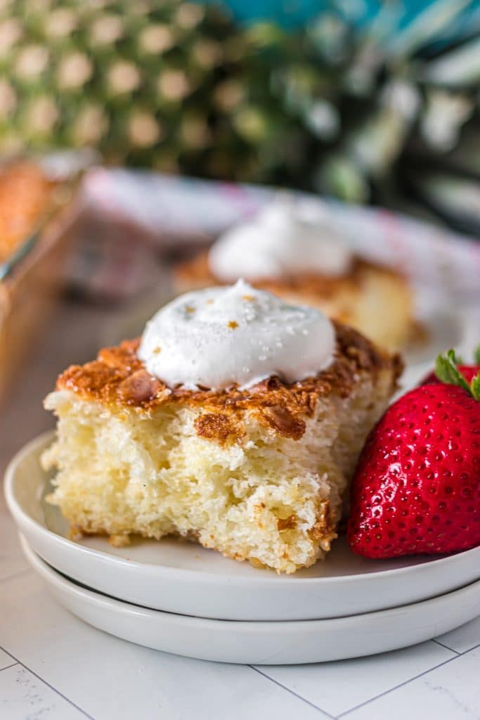 slice of pineapple angel food cake topped with whipped cream.