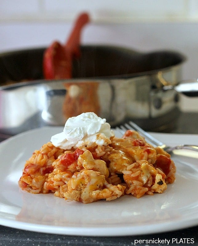 One pot and 30 minutes are all you need for this Southwest Chicken Skillet! Big flavor without a lot of effort. | www.persnicketyplates.com #chickendinner #30minutemeal #skilletdinner #onepotwonder #easyrecipe serving of southwest chicken on a plate topped with sour cream