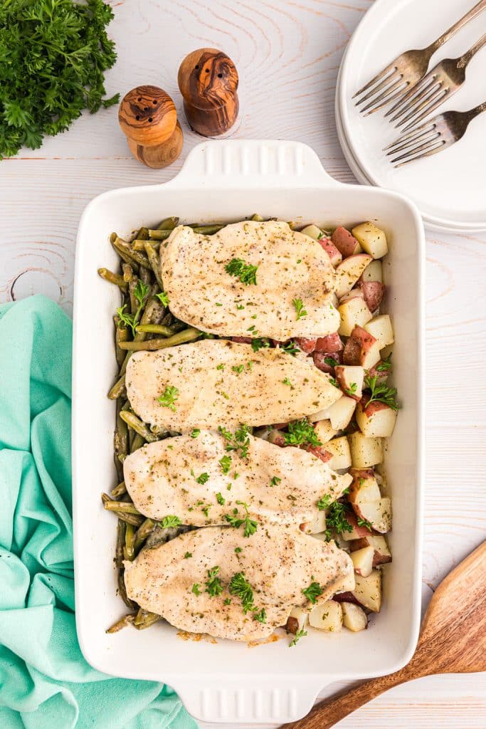 overhead shot of chicken potatoes & green beans in a baking dish.