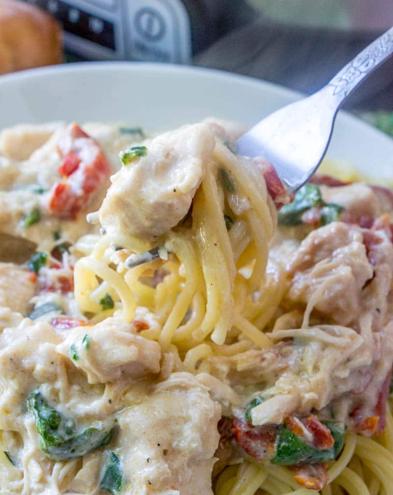 Five ingredient, super simple, Crock Pot Chicken Alfredo takes no time at all to throw together in the slow cooker. This easy crockpot chicken alfredo recipe will become a staple in your meal plan. forkful of crock pot chicken alfredo pasta