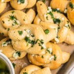 overhead shot of a pile of garlic knots topped with parsley.