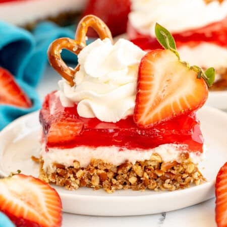 slice of strawberry pretzel dessert topped with whipped cream.
