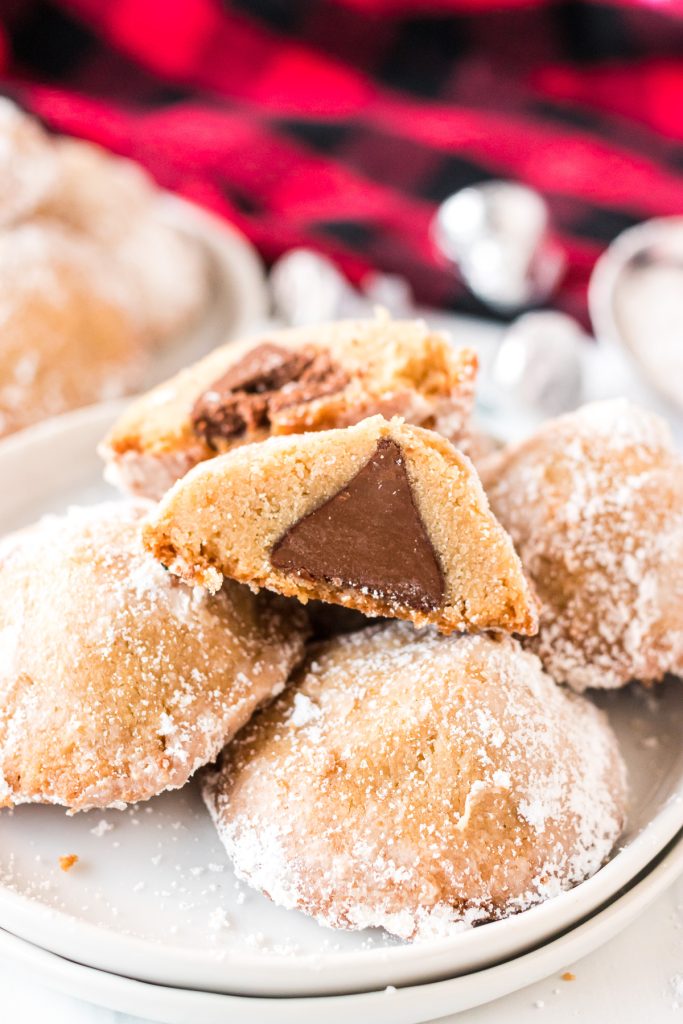 plate of cookies with one sliced in half showing a hershey's kiss inside