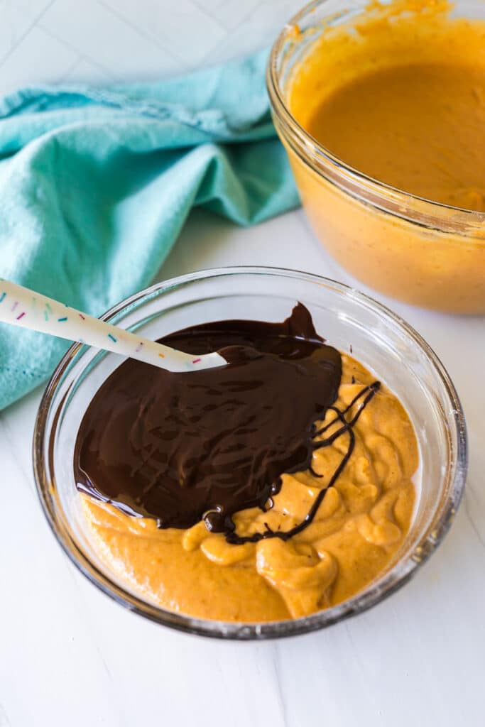 melted chocolate poured into pumpkin cake batter.