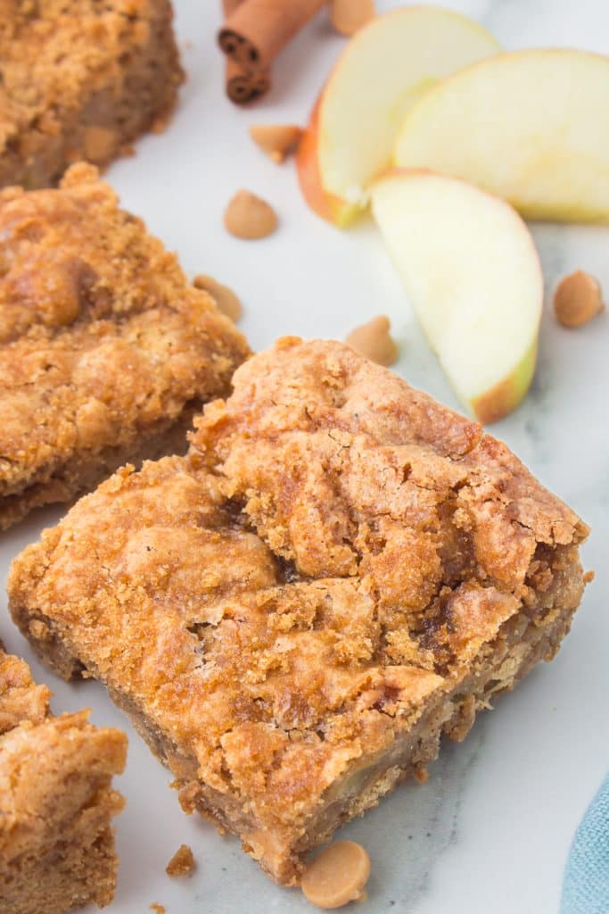 an apple blondie next to some apple slices.