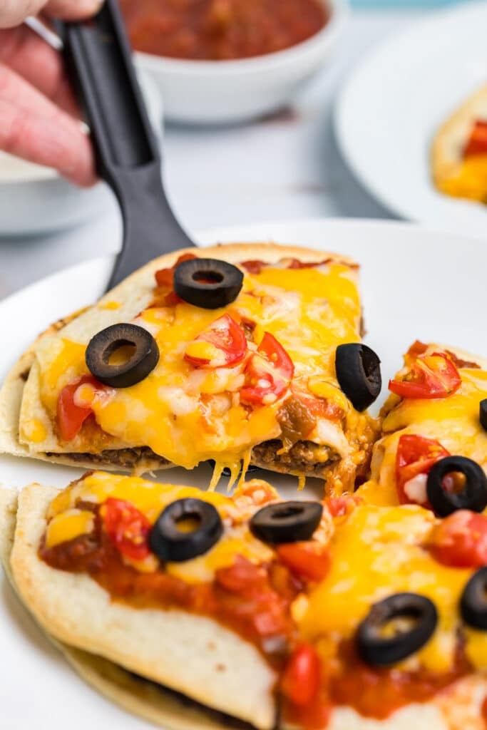 slice of mexican pizza being lifted from the plate.