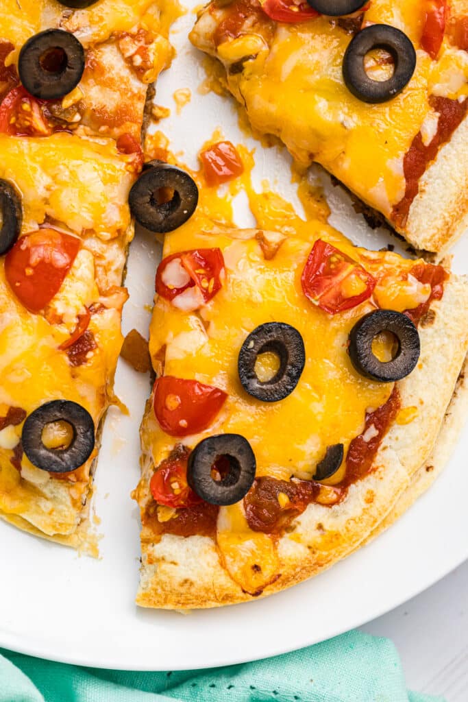 overhead shot of mexican pizza topped with black olives.