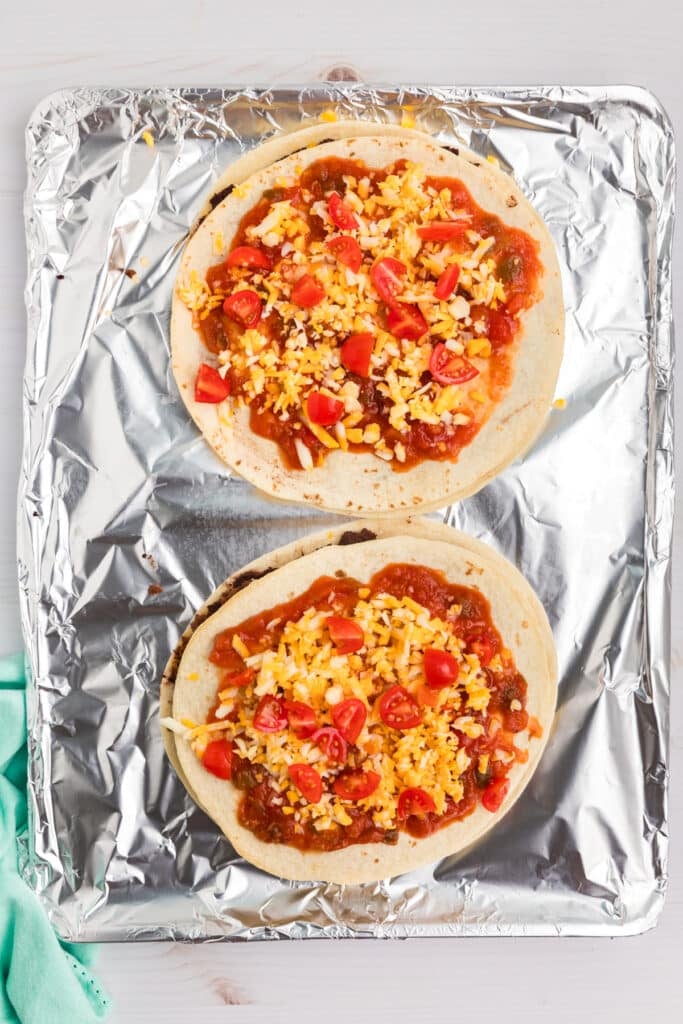 two mexican pizzas before baking on foil.