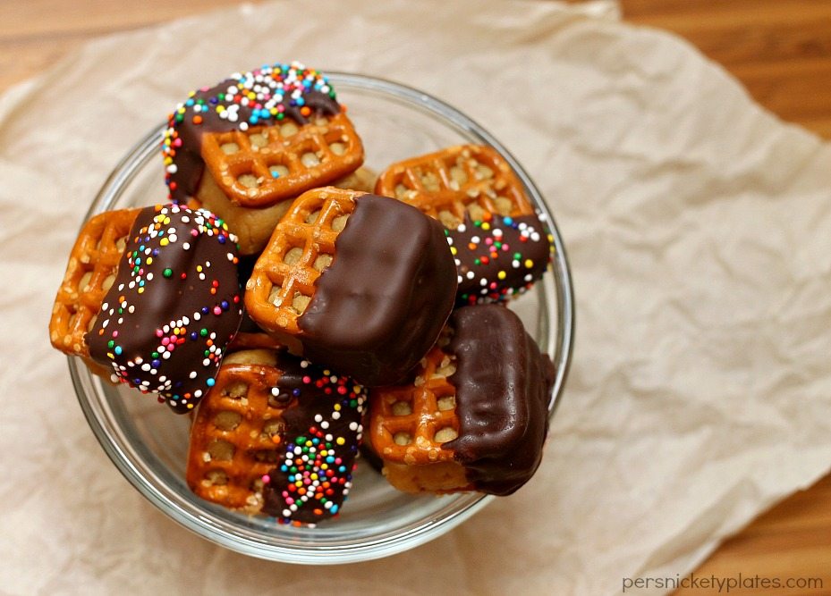 glass bowl filled with chocolate dipped peanut butter pretzel bites