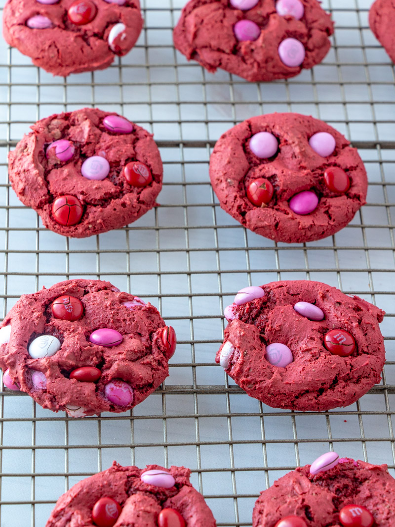 red cookies on a cooling rack