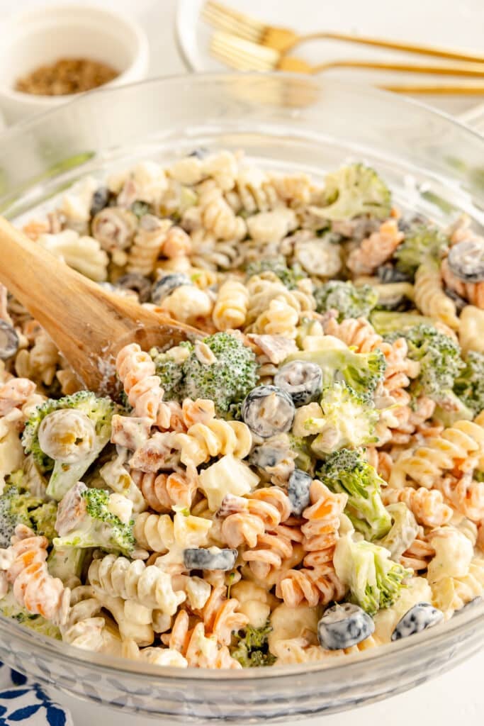 glass mixing bowl of tri-colored pasta salad.