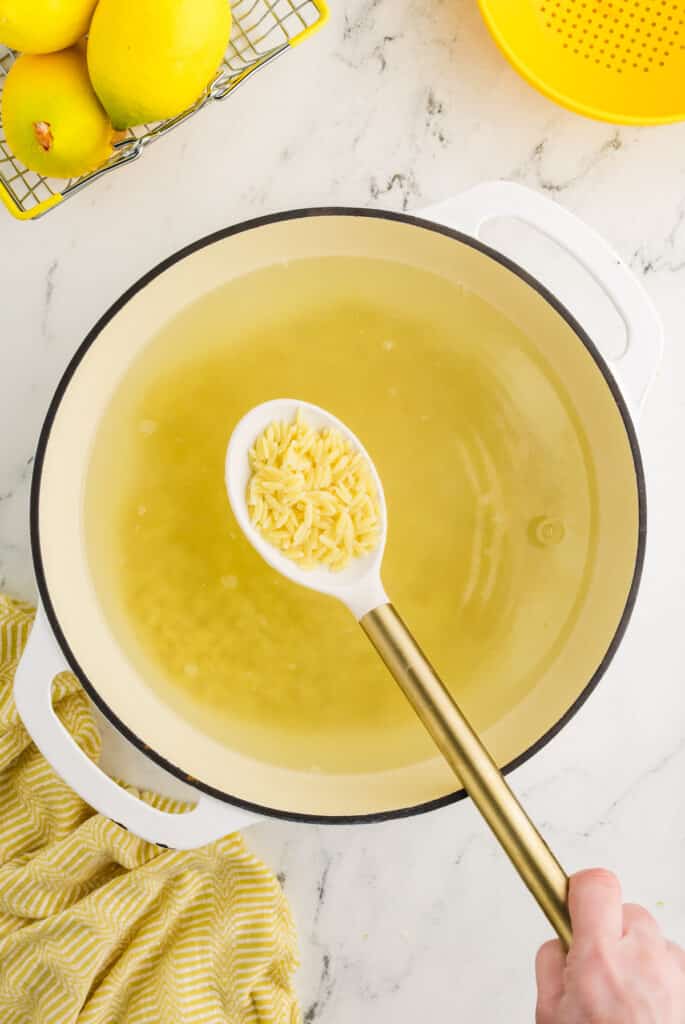 cooked orzo being lifted from a pot.