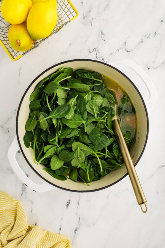 fresh baby spinach in a soup pot.